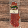 Packaged pork jerky with a label on a wooden surface