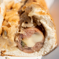 Close-up of a sliced Russian Reuben Brats on a bun