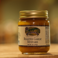 A jar of Roasted Garlic Mustard on a wooden surface