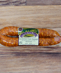 Packaged Romanian Style Sausage on a wooden surface.