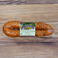Packaged Romanian Style Sausage on a wooden surface.