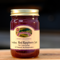 A jar of Seedless Red Raspberry Jam on a wooden surface