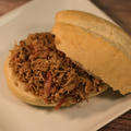 A Southern Style Pulled Pork sandwich on a bun and a white plate