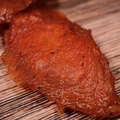 close up of Spicy Honey BBQ Turkey Jerky on a wooden surface