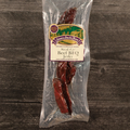 Packaged Beef Steak Cut BBQ Jerky with a label on a wooden surface