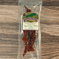 Packaged Steak Cut Beef Spicy BBQ Jerky with a label on a wooden surface