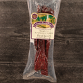 Packaged steak cut raspberry chipotle beef jerky with a label on a wooden surface