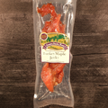 Packaged turkey maple jerky with a label on a wooden surface