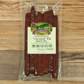 Packaged Uncured Elk Snack Stix with a label on a wooden background