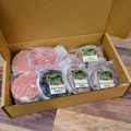 A Variety of Gourmet Burger Patties in a box on a wooden surface.