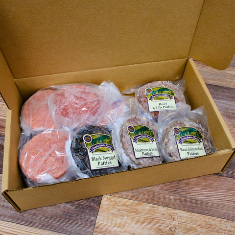 A Variety of Gourmet Burger Patties in a box on a wooden surface.