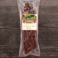 Packaged Venison Cajun Jerky with a label on a wooden surface
