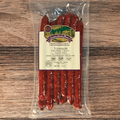 Packaged venison cheddar cheese snack sticks on a wooden surface