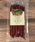 Packaged venison cherry cheddar jalapeno snack sticks with a label on a wooden surface