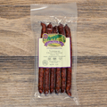 Packaged Venison Cherry Cheddar Snack Stix with a label on a wooden surface