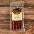 Packaged Venison Dill Pickle Snack Stix on a wooden surface