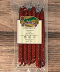 Packaged venison hot snack sticks with a label on a wooden surface