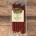 Packaged Venison Hot Snack Stix with a label on a wooden surface