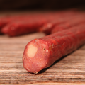 Close-up of sliced Venison jalapeno cheese snack Sticks  on a wooden surface