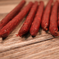 Close-up of Venison jalapeno cheese snack Sticks  on a wooden surface
