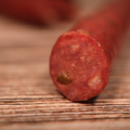 Close-up of a sliced Venison Jalapeno Pepper Snack Stix on a wooden surface