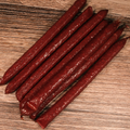 Unpackaged Venison Jalapeno Pepper Snack Stix on a wooden surface