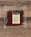 Packaged venison snack sticks on a wooden surface
