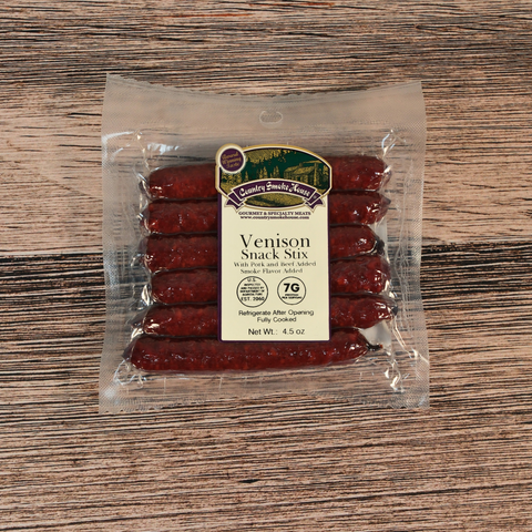 Packaged venison snack sticks on a wooden surface