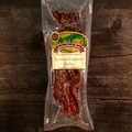 Packaged venison peppered jerky on a wooden surface with a visible brand label.