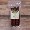 Packaged Venison Whiskey Snack Stix with a label on a wooden surface