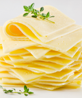 A stack of thin, pale yellow cheese slices with small holes, garnished with two small green herb sprigs, photographed on a clean white background.
